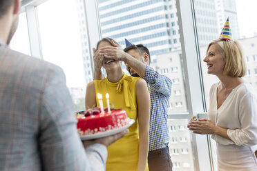 Business people celebrating birthday with cake in office - CAIF09750