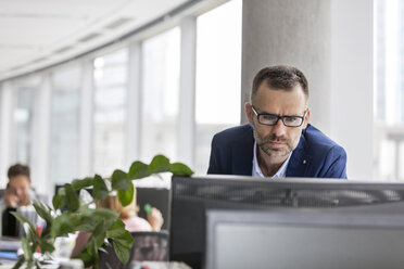 Serious businessman working at computer in office - CAIF09755