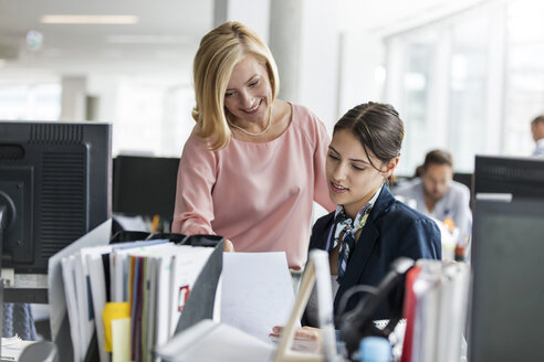 Geschäftsfrauen besprechen Papierkram im Büro - CAIF09764