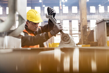 Stahlarbeiter mit großem Schraubenschlüssel in einer Fabrik - CAIF09771