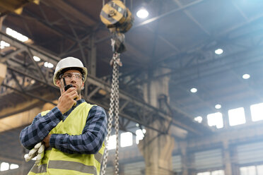 Stahlarbeiter mit Walkie-Talkie in einer Fabrik - CAIF09780