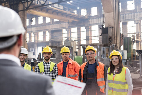 Stahlarbeiter hören dem Manager bei einer Besprechung in der Fabrik zu - CAIF09782