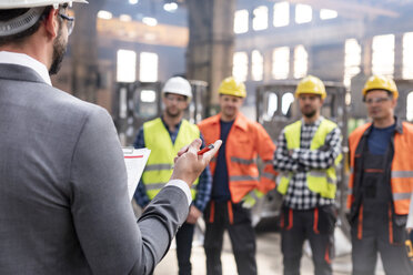 Stahlarbeiter hören dem Manager bei einer Besprechung in der Fabrik zu - CAIF09794