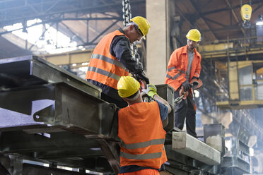 Stahlarbeiter befestigen Kranhaken an Stahl in Arbeiter - CAIF09802
