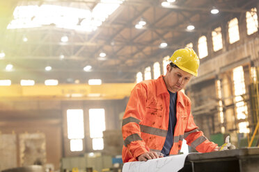 Ingenieur bei der Überprüfung von Plänen in einer Stahlfabrik - CAIF09815