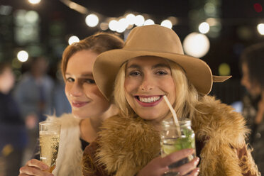 Portrait lächelnde junge Frauen trinken Cocktails auf einer Party - CAIF09822