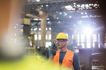 Stahlarbeiter mit Walkie-Talkie in der Fabrik - CAIF09836