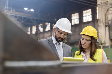Manager and female steel worker meeting in factory - CAIF09837