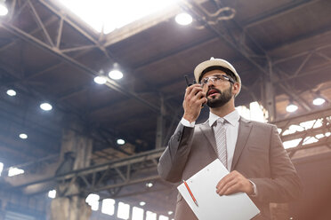 Manager mit Walkie-Talkie im Stahlwerk - CAIF09841