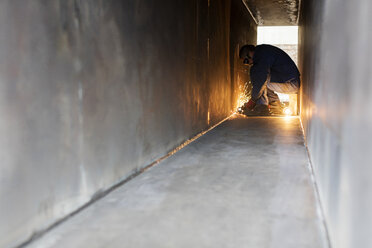 Welder using welding torch in steel tunnel - CAIF09844