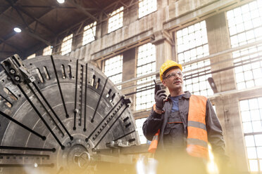 Stahlarbeiter mit Walkie-Talkie in der Fabrik - CAIF09852