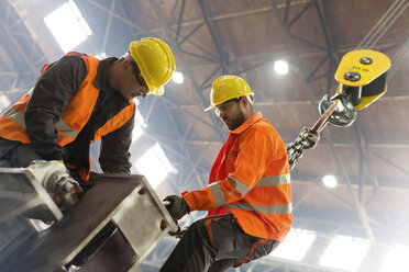 Stahlarbeiter befestigen Kranhaken an Stahl in einer Fabrik - CAIF09870