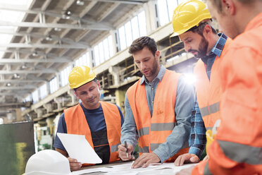 Treffen von Stahlarbeitern und Ingenieuren bei der Überprüfung von Entwürfen in einer Fabrik - CAIF09872