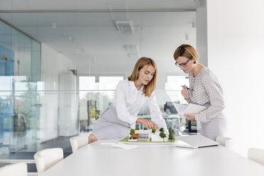 Architektinnen diskutieren in einem Konferenzraum über ein Modell - CAIF09921