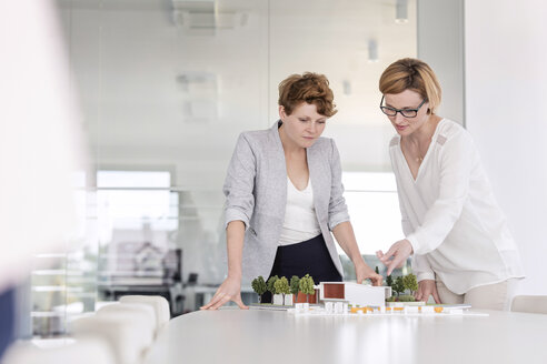 Architektinnen diskutieren in einem Konferenzraum über ein Modell - CAIF09938