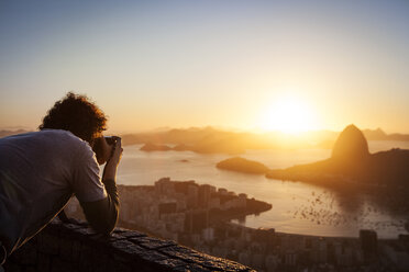 Mann fotografiert den Sugarloaf Mountain bei Sonnenuntergang - CAVF04933