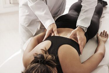 Osteopath examining woman at clinic - CAVF04953