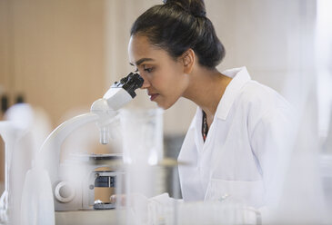 Female scientist using microscope in laboratory - CAIF09990