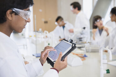 Ein männlicher Student benutzt ein digitales Tablet in einem wissenschaftlichen Labor - CAIF10008