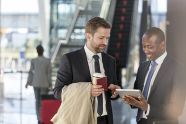 Geschäftsleute mit digitalem Tablet im Gespräch am Flughafen - CAIF10023