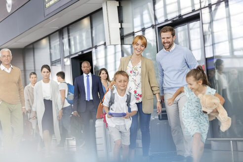Familie beim Gehen und Laufen in der Flughafenhalle - CAIF10024