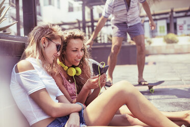 Young women hanging out with headphones and mp3 player - CAIF10141