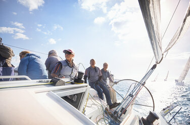 Freunde im Ruhestand auf einem Segelboot auf dem sonnigen Meer - CAIF10149