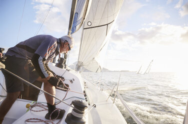 Retired man sailing on sunny ocean - CAIF10155