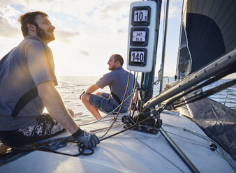 Männer überwachen den Wind auf einem Segelboot - CAIF10181