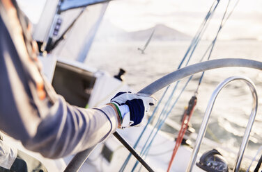 Man sailing steering sailboat at helm - CAIF10184