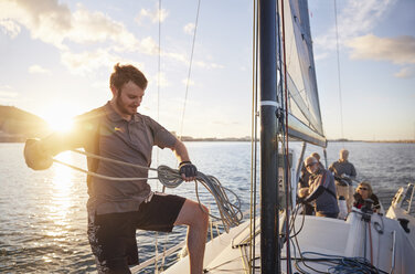 Man sailing looping rigging on sailboat - CAIF10188