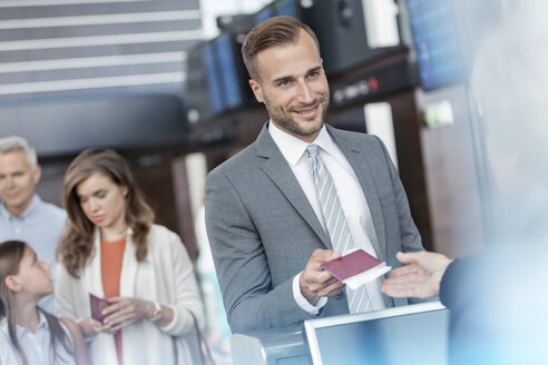 Geschäftsmann mit Reisepass am Flughafen-Check-in-Schalter - CAIF10200