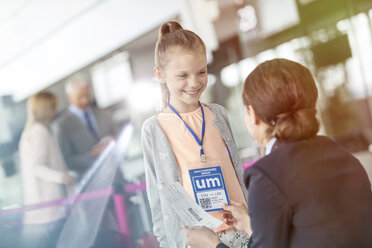 Flugbegleiterin im Gespräch mit einem Mädchen im Flughafen - CAIF10243