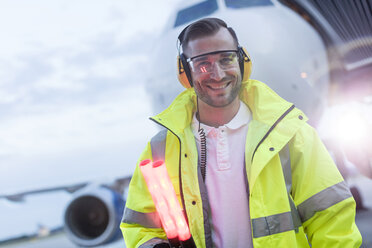 Portrait smiling air traffic controller in front of airplane on tarmac - CAIF10253