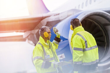 Airport ground crew workers talking near airplane - CAIF10264