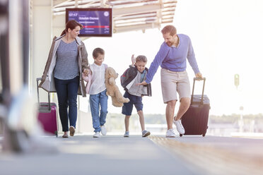 Familie geht mit Koffern am Bahnhof - CAIF10272