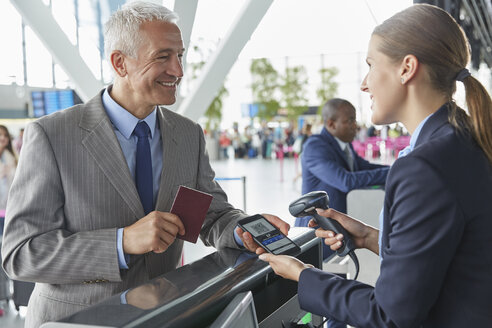 Kundendienstmitarbeiter scannt Smartphone-QR-Code-Bordkarte am Flughafen-Check-in-Schalter - CAIF10309