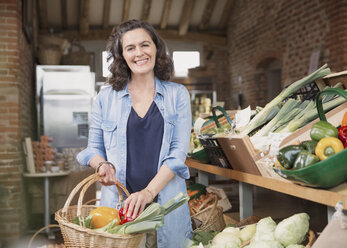 Porträt einer lächelnden Frau, die auf dem Markt frische Produkte einkauft - CAIF10354