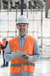 Portrait confident male engineer with clipboard at construction site - CAIF10449