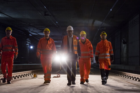 Männlicher Polier und Bauarbeiter auf einer dunklen Baustelle im Untergrund - CAIF10455