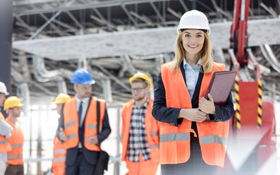 Porträt einer lächelnden Ingenieurin auf einer Baustelle - CAIF10458