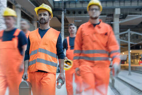 Bauarbeiter gehen zum Mittagessen auf die Baustelle - CAIF10477