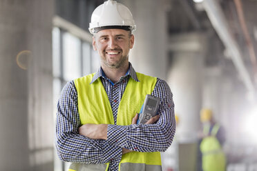 Portrait smiling engineer at construction site - CAIF10489