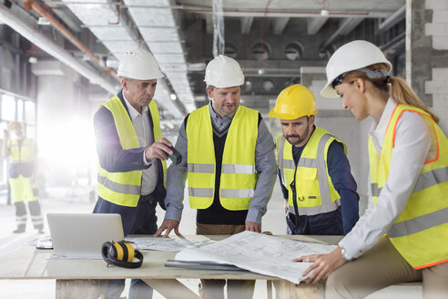 Ingenieure bei der Überprüfung von Bauplänen auf der Baustelle - CAIF10492