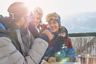 Lächelnde Skifahrerfreunde trinken Cocktails beim Après-Ski - CAIF10535