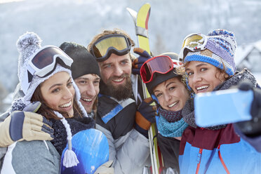 Lächelnde Skifahrerfreunde machen ein Selfie mit einem Fotohandy - CAIF10536