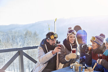 Snowboarder und Skifahrer trinken Cocktails auf dem Balkon beim Après-Ski - CAIF10543