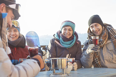 Snowboarder-Freunde trinken Cocktails auf der sonnigen Terrasse beim Après-Ski - CAIF10567