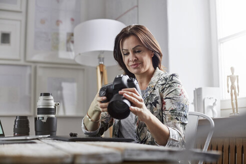 Fotografin mit Digitalkamera im Büro - CAIF10583