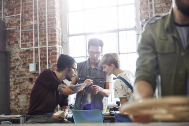 Designers examining prototype in workshop - CAIF10600